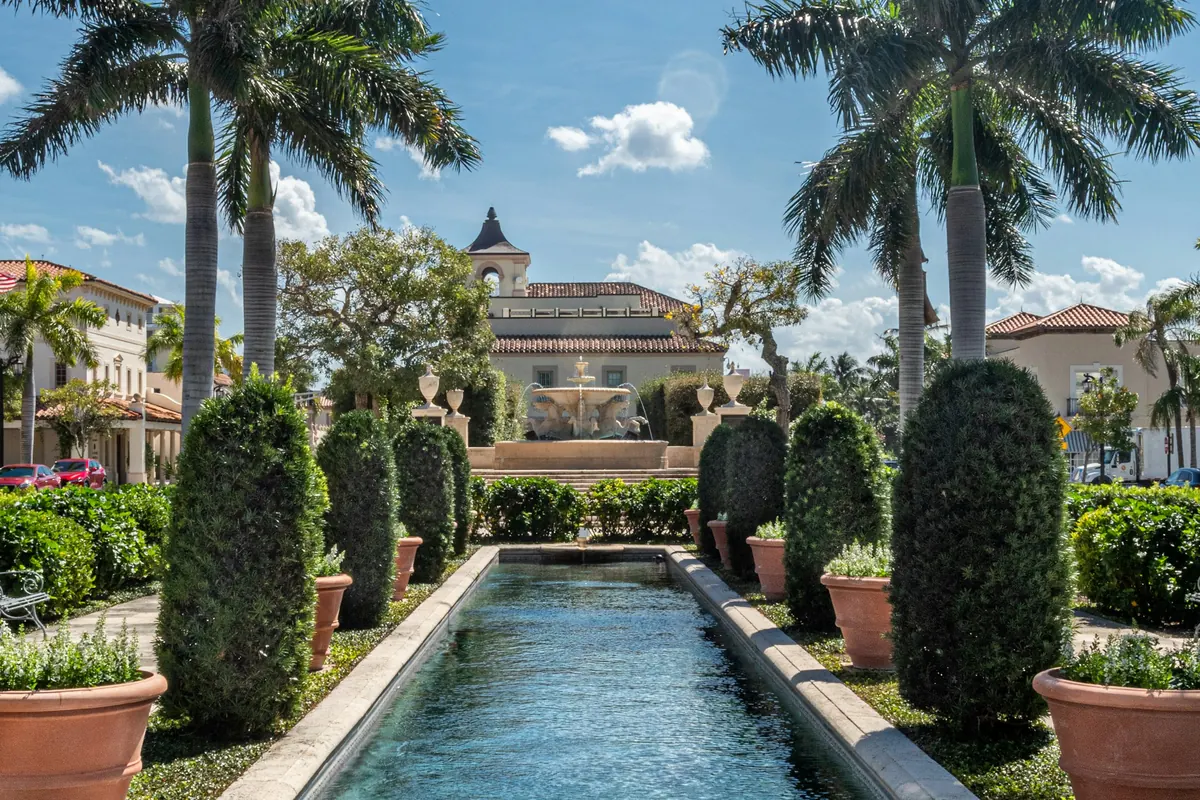Formal garden with a long pool and palms